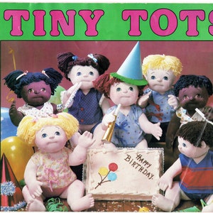 May include: A group of seven dolls dressed in colorful outfits are gathered around a birthday cake. The cake is decorated with the words "Happy Birthday" and colorful balloons. The dolls are all smiling and appear to be celebrating a birthday.