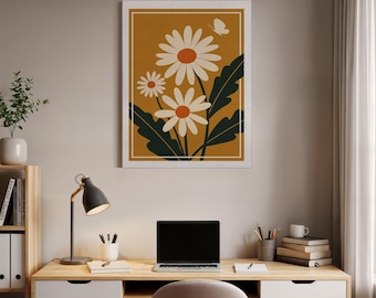 Puede incluir: Una impresión artística enmarcada que presenta una ilustración estilizada de margaritas. La obra de arte tiene un fondo amarillo mostaza con margaritas blancas, centros naranjas y hojas verdes oscuras. También se incluye una mariposa blanca.