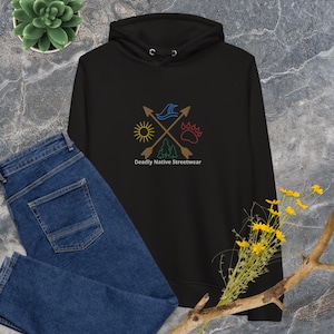 May include: Black hooded sweatshirt with a graphic design of four symbols: a sun, a wave, a tree, and a bear paw print. The symbols are arranged in a circle with arrows pointing outwards. The text "Deadly Native Streetwear" is printed below the graphic.