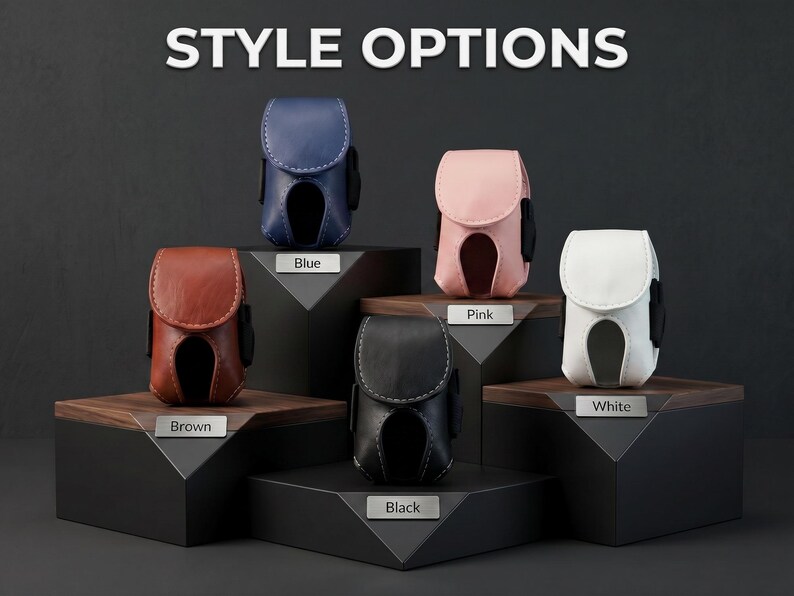May include: Five small, structured cases with flap closures and cut-out bottoms, displayed in blue, brown, pink, black, and white. Each case features visible stitching and is labeled with its respective color on a small metal plaque.