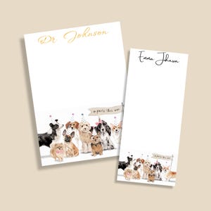 May include: Two white notepads with personalized names in gold and black script. The bottom of each notepad features a watercolor illustration of various dog breeds wearing party hats and a banner that reads "party this way."