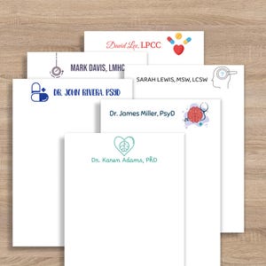 May include: A stack of white notepads with various names and titles printed in different fonts and colors. The notepads feature the names: David Lee, Mark Davis, Sarah Lewis, Dr. John Rivera, Dr. James Miller, and Dr. Karen Adams.