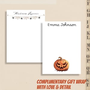 May include: Two white notepads with personalized names. One notepad has "Andrew Harris" with spider web and spider decorations. The other notepad has "Emma Johnson" with a jack-o'-lantern illustration. Text at the bottom reads "COMPLIMENTARY GIFT WRAPS WITH LOVE & DETAIL."