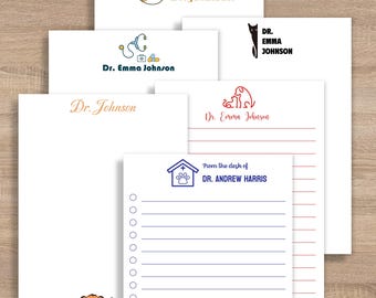 May include: A collection of personalized stationery featuring veterinary-themed designs. The notepads include various illustrations of pets, stethoscopes, and paw prints, with names like "Dr. Johnson" and "Dr. Emma Johnson" printed on them.