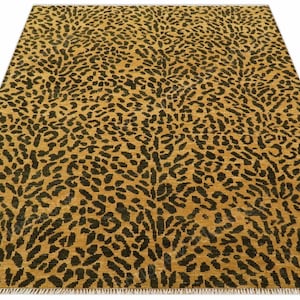 以下が含まれることがあります： 金色の背景に黒い斑点が繰り返される模様の長方形のラグ。ラグの下端にはフリンジが付いています。デザインはヒョウ柄に似ており、どんな部屋にもワイルドなスタイルを添えます。