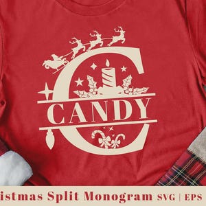 May include: Red t-shirt featuring a cream-colored Christmas-themed design. The design includes a large letter "C" with a candle, stars, holly, and the word "CANDY". Above the "C" are reindeer pulling a sleigh.