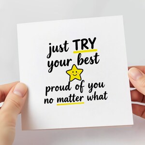 May include: A white greeting card with the text "just TRY your best proud of you no matter what" in black script. The word "TRY" and "best" are underlined in yellow. A yellow star with a smiling face is in the center.
