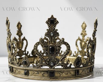 Op de afbeelding: Een antiek gouden kroon met zwarte edelstenen. De kroon heeft een sierlijk ontwerp met decoratieve versieringen en staat op een wit marmeren oppervlak. De tekst "VOW CROWN" is zichtbaar.