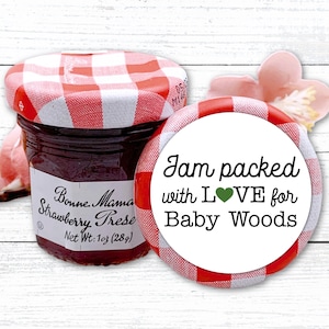 May include: A jar of Bonne Maman strawberry preserves with a red and white checkered lid. A round sticker with the text "Jam packed with LOVE for Baby Woods" is next to the jar. Net weight: 1 oz (28g).