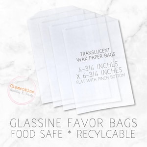 May include: A stack of four translucent wax paper bags with a pinch bottom. The bags are 4-3/4 inches by 6-3/4 inches and are food safe and recyclable. The text "TRANSLUCENT WAX PAPER BAGS" is printed on the bags.
