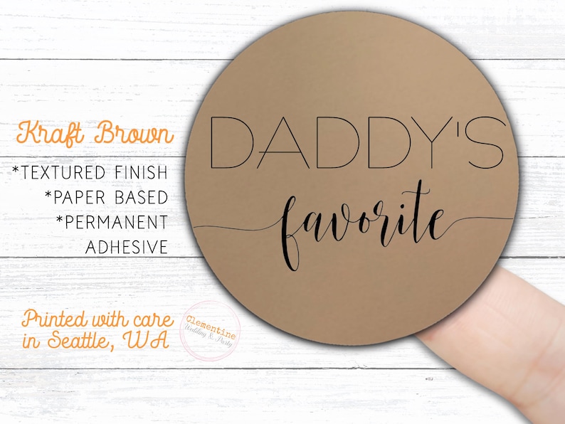 Round label is shown stuck on a fingertip.  Overlay text: 'Kraft Brown: Textured finish, paper based, permanent adhesive. Printed with care in Seattle WA by Clementine Wedding & Party.'