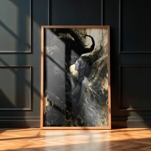 May include: A framed art print featuring a woman in a flowing gown, with dark, swirling abstract elements. The artwork is primarily black and gold, with a wooden frame. The print is displayed on a dark wall with a wooden floor.
