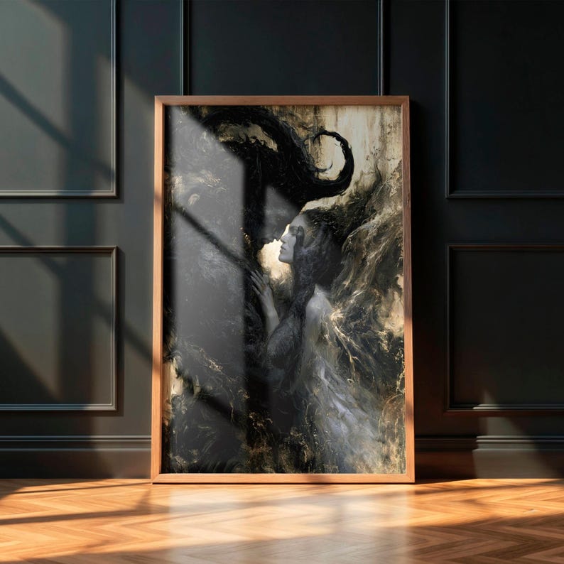 May include: A framed art print featuring a woman in a flowing gown, with dark, swirling abstract elements. The artwork is primarily black and gold, with a wooden frame. The print is displayed on a dark wall with a wooden floor.