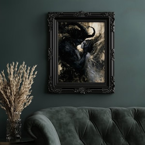 May include: A framed artwork depicting a dark figure embracing a woman in a flowing white gown. The black frame has ornate detailing. The artwork is displayed on a dark green wall above a green velvet sofa.