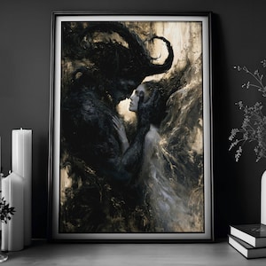 May include: Framed art print depicting a dark, romantic scene. A shadowy figure with large horns embraces a woman. The artwork features a palette of blacks, grays, and gold, creating a dramatic and ethereal atmosphere. The print is in a black frame.