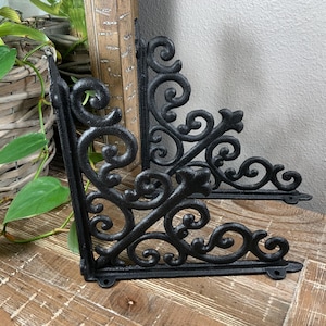 May include: A white ceramic mug with a black handle and the text "But First, Coffee" in a bold, black font. The mug is set against a blurred background, suggesting a cozy setting.