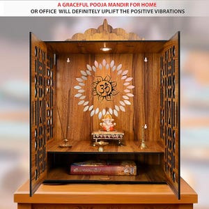 Puede incluir: Mandir de Pooja de madera con intrincados dise&ntilde;os calados en las puertas. El interior presenta un s&iacute;mbolo Om y una peque&ntilde;a estatua. El texto en la parte superior dice: "A GRACEFUL POOJA MANDIR FOR HOME OR OFFICE WILL DEFINITELY UPLIFT THE POSITIVE VIBRATIONS."