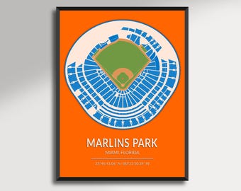 May include: A framed print featuring a detailed, top-down view of Marlins Park in Miami, Florida. The stadium is depicted in blue and green against a white circular background, set on an orange backdrop. Text includes the stadium name and coordinates.