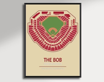 May include: A framed print featuring a top-down view of a baseball stadium, rendered in red and green on a beige background. The text "THE BOB PHOENIX, ARIZONA" is displayed below the stadium illustration, along with coordinates.