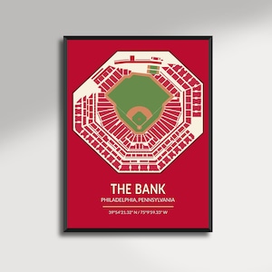 May include: A framed print featuring a detailed, top-down view of a baseball stadium, rendered in white against a red background. The stadium's layout is precise, with seating sections and the field clearly defined. Text at the bottom reads "THE BANK, PHILADELPHIA, PENNSYLVANIA".