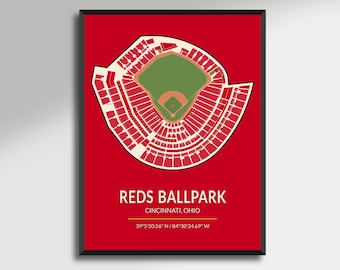 May include: A framed print featuring a detailed, stylized map of the Reds Ballpark in Cincinnati, Ohio, set against a vibrant red background. The stadium is depicted in white and green, with the text "REDS BALLPARK" and coordinates at the bottom.