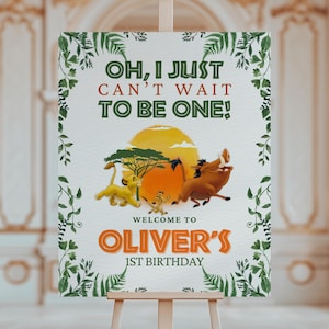 May include: A decorative sign featuring characters from The Lion King, with the text "OH, I JUST CAN'T WAIT TO BE ONE!" and "WELCOME TO OLIVER'S 1ST BIRTHDAY." The design includes a yellow sun, a tree, and green foliage.