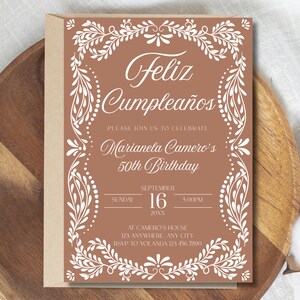 Peut inclure: Une invitation d'anniversaire marron avec une bordure florale blanche et du texte. L'invitation indique "Feliz Cumplea&ntilde;os" et annonce le 50e anniversaire de Marianela Camero le 16 septembre &agrave; 17h00. Comprend les informations RSVP.