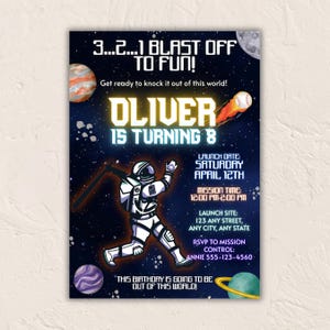 Puede incluir: Invitación de cumpleaños con temática espacial con un fondo azul oscuro con planetas, estrellas y un astronauta. La invitación dice "Oliver cumple 8 años" e incluye detalles del evento. También se muestra una pelota de béisbol con llamas.