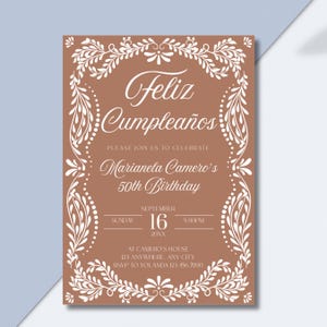 Peut inclure: Une invitation d'anniversaire avec un fond marron et une bordure florale blanche. Le texte "Feliz Cumplea&ntilde;os" est en haut, suivi des d&eacute;tails pour le 50e anniversaire de Marianela Camero, y compris la date, l'heure et le lieu.