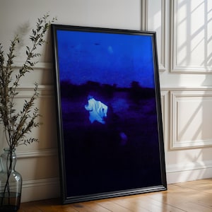 Op de afbeelding: Een ingelijste kunstdruk met donkerblauwe en zwarte tinten. Het kunstwerk toont een witte figuur tegen een donkere achtergrond. Het zwarte frame leunt tegen een witte muur en een houten vloer.