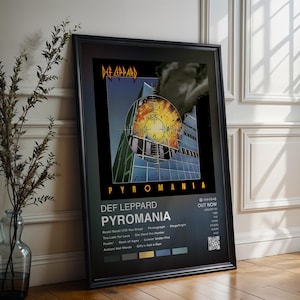 Könnte beinhalten: Gerahmtes Poster mit dem Def Leppard Album Pyromania. Das Kunstwerk zeigt ein futuristisches Gebäude mit einer feurigen Explosion in der Mitte. Das Poster enthält den Albumtitel, den Bandnamen und die Titelliste.
