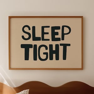 May include: A bedroom scene featuring a wooden headboard and a bed with striped bedding. A framed print on the wall reads "SLEEP TIGHT" in dark blue letters. The room is bathed in soft, natural light.