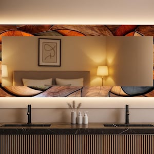 May include: Rectangular bathroom mirror with a decorative wooden frame featuring a mosaic of brown, orange, and gray shapes. The mirror has a built-in LED light and is mounted above a dark countertop with black faucets.
