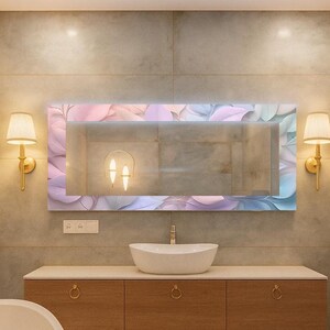 May include: A modern bathroom featuring a large rectangular mirror with a floral design in pastel colors. The mirror is above a wooden vanity with a white vessel sink. Gold sconces and a towel rack add to the elegant decor.