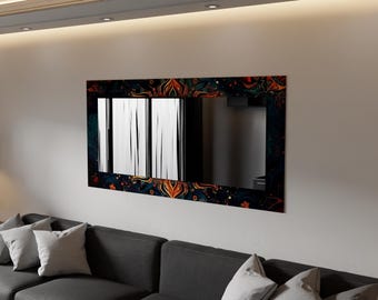 Op de afbeelding: Rechthoekige wandspiegel met een donkerblauwe lijst met een ingewikkeld bloemmotief in oranje, rood en geel. De spiegel reflecteert een kamer met witte verticale jaloezieën. De spiegel is gemonteerd op een witte muur boven een grijze bank.