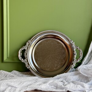 Vintage verzilverd rond dienblad met sierlijke handgrepen