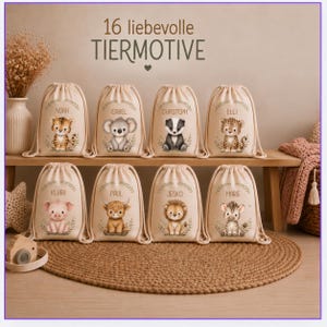 Könnte beinhalten: Acht beige Turnbeutel in zwei Reihen, jeder mit einer individuellen Aquarell-Tierillustration und einem darüber gedruckten Namen. Der Text 16 liebevolle TIERMOTIVE steht zentriert über den Beuteln. Die Beutel haben Kordelverschlüsse.