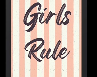 May include: Framed wall art with a black border. The artwork features a vertical striped background in alternating shades of peach and white. The words "Girls Rule" are written in a dark purple, cursive font.