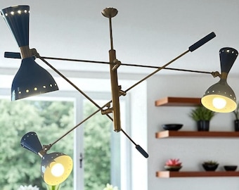 May include: A mid-century modern chandelier with a brass finish and navy blue cone-shaped shades. Each shade has small, evenly spaced holes. The fixture has multiple arms extending from a central stem, with a total of four lights. The light fixtures are suspended from the ceiling.