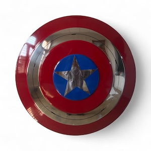May include: A round shield with a red outer ring, a silver middle ring, and a red center. A blue circle with a silver star is in the center. The shield is a replica of a superhero's shield.