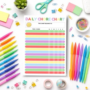 Puede incluir: Un colorido gráfico de tareas diarias con el texto "DAILY CHORE CHART" y un icono de carita sonriente. El gráfico tiene un espacio para el nombre del propietario y una lista de tareas. Alrededor del gráfico hay bolígrafos de colores, tijeras, clips y notas adhesivas.