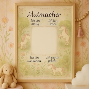 Könnte beinhalten: Ein gerahmter Druck mit dem deutschen Wort "Mutmacher" oben, mit Illustrationen von Einhörnern und Text auf Deutsch. Der Druck hat einen hellen Holzrahmen und wird in einem Kinderzimmer ausgestellt.