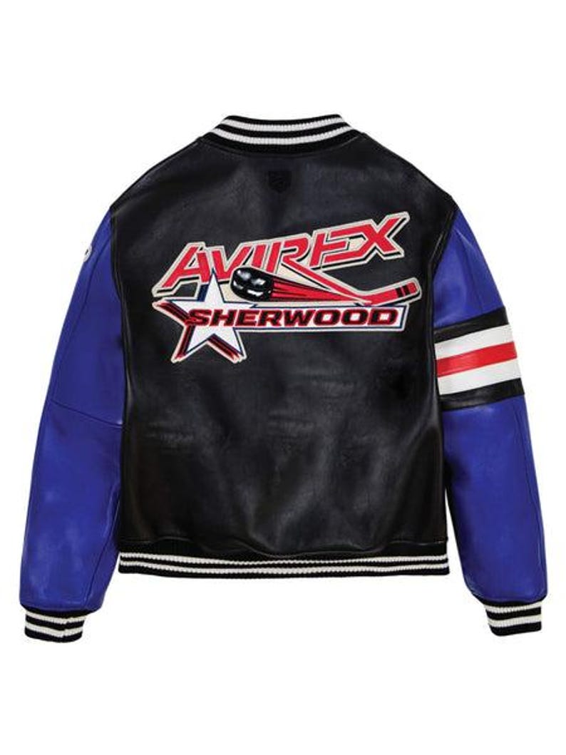 May include: Black leather varsity jacket with blue sleeves and white, red, and black striped accents. The back features the text "AVIREX SHERWOOD" with a hockey stick and star graphic.
