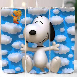 May include: A set of three stainless steel tumblers featuring a cartoon design of Snoopy and Woodstock against a blue sky with white clouds. Each tumbler has a white straw.
