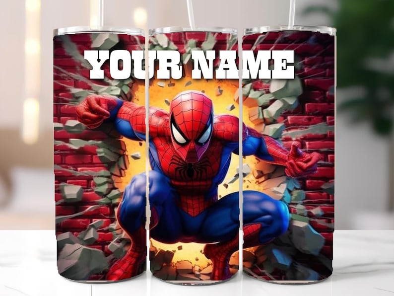 May include: A stainless steel tumbler featuring a vibrant illustration of Spider-Man breaking through a brick wall. The design includes the text "YOUR NAME" in bold white letters. The tumbler has a straw.