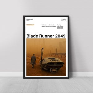May include: Framed poster for the film "Blade Runner 2049." The image features a lone figure walking towards a futuristic vehicle in a desolate, orange-hued landscape. The poster includes the film's title and credits.