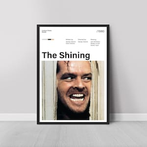 Puede incluir: Un póster enmarcado de la película "El Resplandor" con un primer plano del rostro de Jack Nicholson. El póster incluye el título de la película, los créditos y el año 1980.