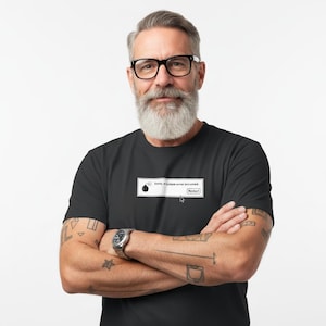 May include: Black t-shirt with a computer error message, including a bomb icon and the text "Sorry. A system error occurred." and a "Restart" button. The shirt is worn by a person with glasses and a beard.