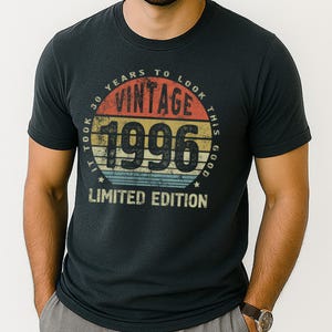 May include: Dark gray t-shirt with a vintage design. The design features the text "VINTAGE 1996" in a circular pattern with the words "IT TOOK 30 YEARS TO LOOK THIS GOOD" and "LIMITED EDITION".