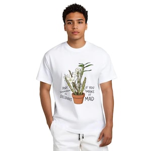 May include: White t-shirt featuring a cartoon illustration of a potted orchid plant with white flowers and green leaves. The text on the shirt reads "ANY Dendrobium IS Deciduous" and "IF YOU MAKE IT MAD".